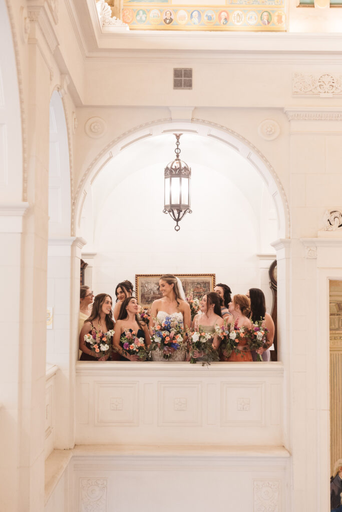 Bride smiles with her bridesmaids on balcony. Wedding day at the American Swedish Historical Museum in Philadelphia, PA. Photographed by South Jersey/Philly based wedding photographer Madison Neumann Photography.