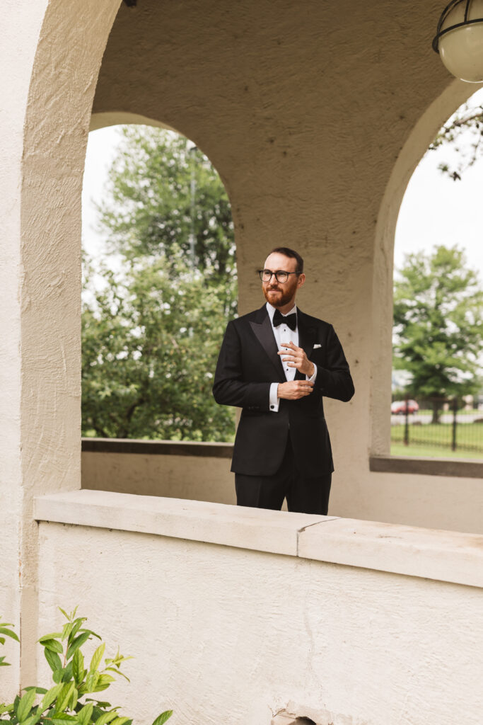 Groom in black tuxedo suit stands outside wedding venue. Wedding day at the American Swedish Historical Museum in Philadelphia, PA. Photographed by South Jersey/Philly based wedding photographer Madison Neumann Photography.