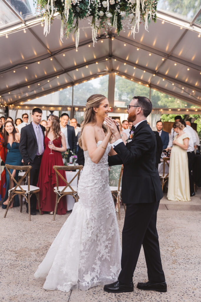 Bride and groom share their first dance at wedding reception while guests watch. Wedding day at the American Swedish Historical Museum in Philadelphia, PA. Photographed by South Jersey/Philly based wedding photographer Madison Neumann Photography.