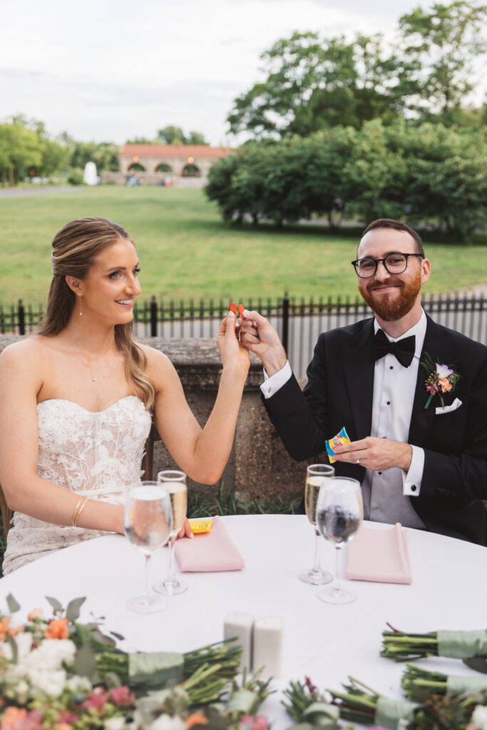 Bride and groom cheers with Swedish Fish wedding favors. Wedding day at the American Swedish Historical Museum in Philadelphia, PA. Photographed by South Jersey/Philly based wedding photographer Madison Neumann Photography.