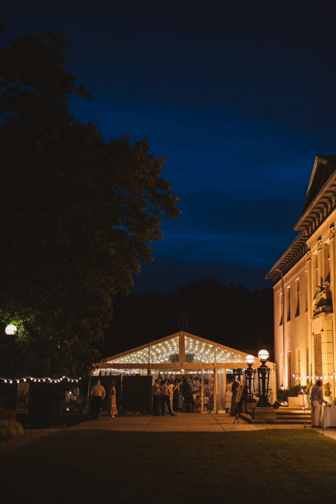 Outdoor nighttime photograph of wedding guests and reception space. Wedding day at the American Swedish Historical Museum in Philadelphia, PA. Photographed by South Jersey/Philly based wedding photographer Madison Neumann Photography.