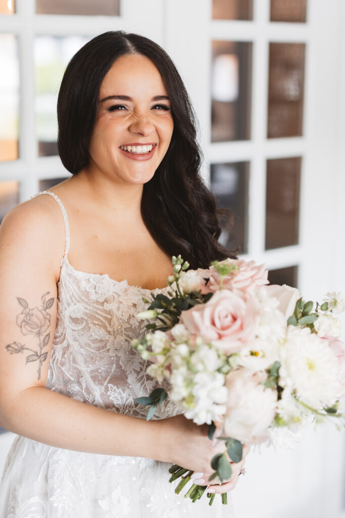 Bride smiling and holding bouquet. Wedding day at Blue Heron Pines Golf Club in Egg Harbor, NJ. Photographed by South Jersey/Philly based wedding photographer Madison Neumann Photography.