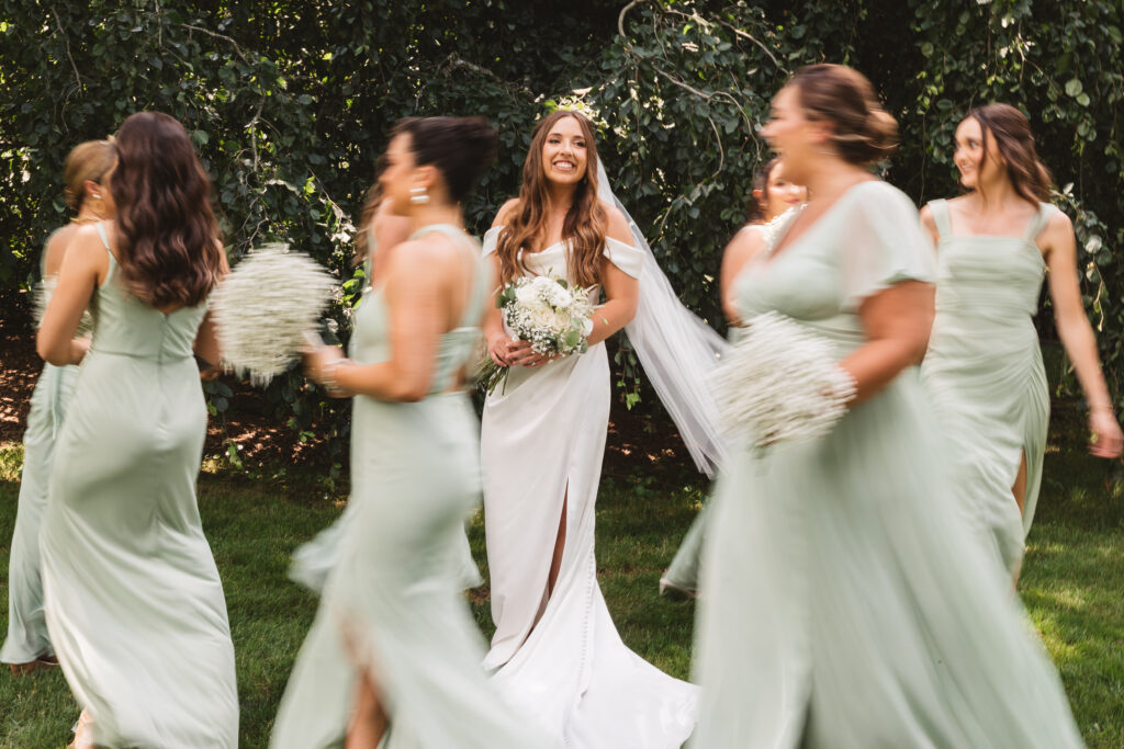 Bride smiling in focus with her bridesmaids running around her in a blur, photographed by New Jersey and Philadelphia based travel wedding photographer Madison Neumann Photography.