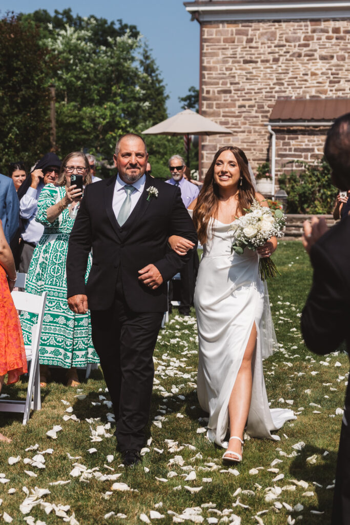 Bride walking down. the isle with her father before he gives her away, photographed by New Jersey and Philadelphia based travel wedding photographer Madison Neumann Photography.