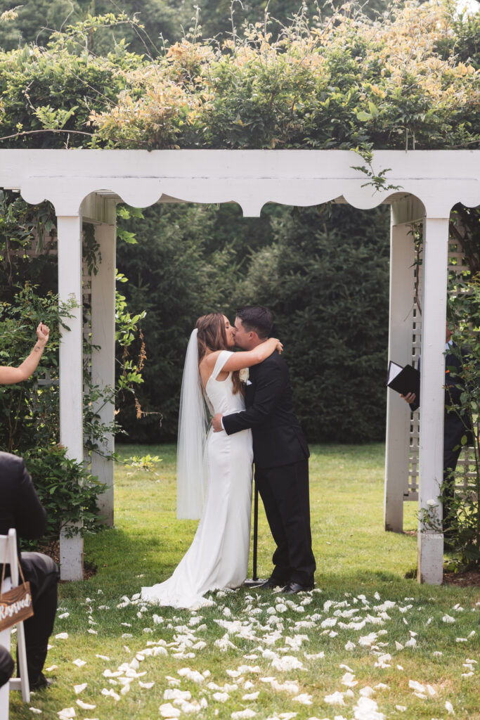 The newly married couple shares their first kiss as man and wife at the altar, photographed by New Jersey and Philadelphia based travel wedding photographer Madison Neumann Photography.