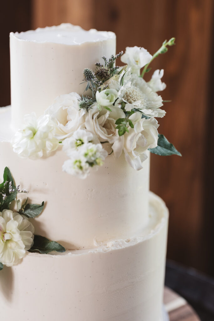 Detail shot of the wedding cake with white flowers and icing, photographed by New Jersey and Philadelphia based travel wedding photographer Madison Neumann Photography.