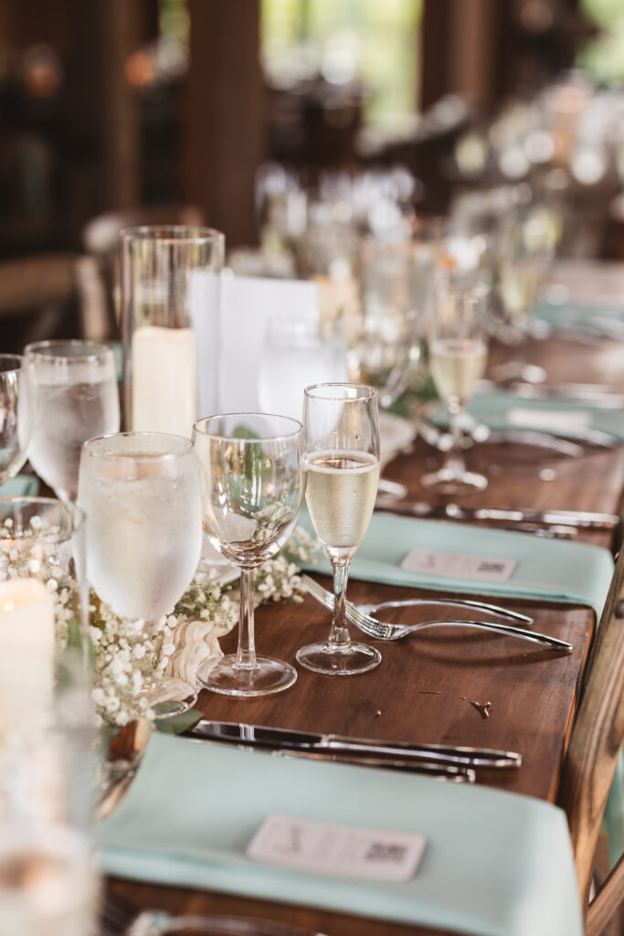 Close up photo of the dining table set up with baby's breath and turquoise napkins in the barn at The Woolverton Inn, photographed by New Jersey and Philadelphia based travel wedding photographer Madison Neumann Photography.