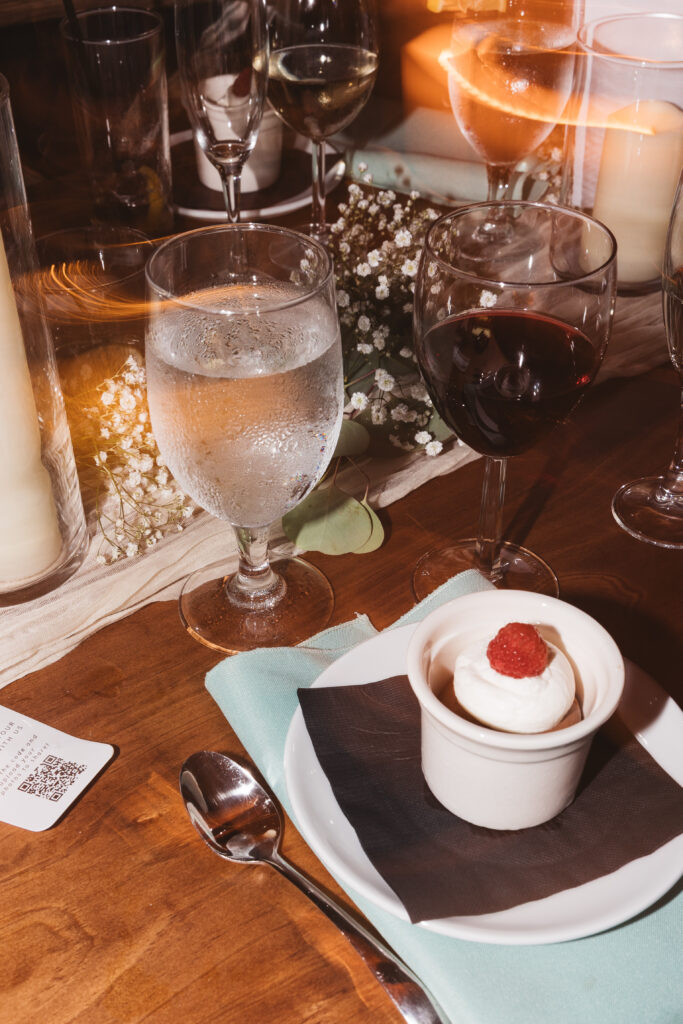 Detail photo of glasses of water and wine with the dessert, photographed by New Jersey and Philadelphia based travel wedding photographer Madison Neumann Photography.