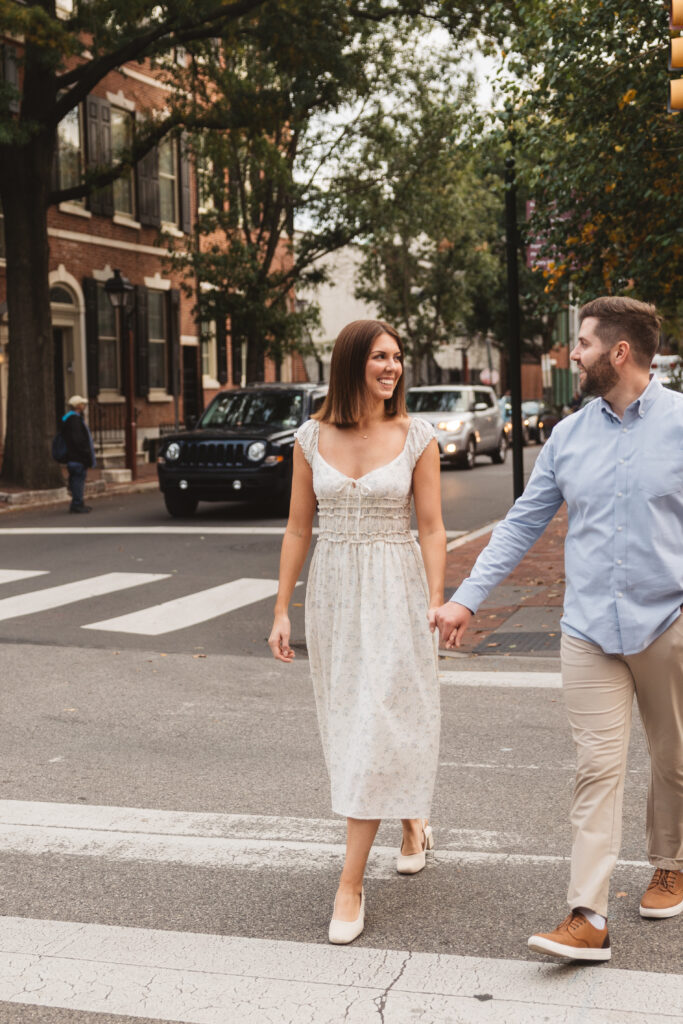 Happy couple crosses the street hand in hand with a smile, photographed by Philadelphia and New Jersey based travel wedding photographer, Madison Neumann Photography.