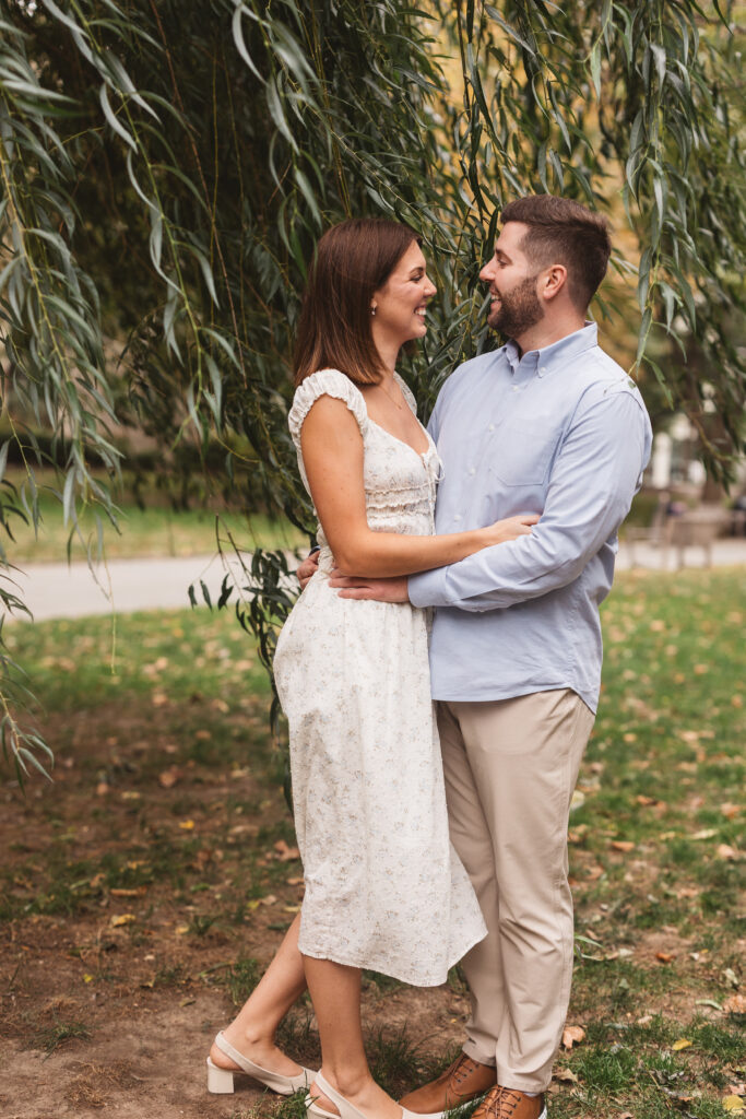 Couple embraces one another under a tree in Washington Square park, photographed by Philadelphia and New Jersey based travel wedding photographer, Madison Neumann Photography.
