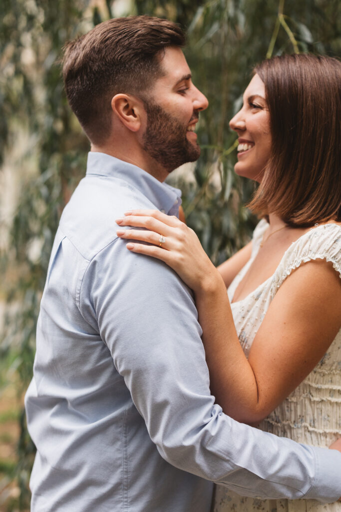 Up close photo of couple with future bride's hand and ring shown as it rests on the future groom's shoulder, photographed by Philadelphia and New Jersey based travel wedding photographer, Madison Neumann Photography.