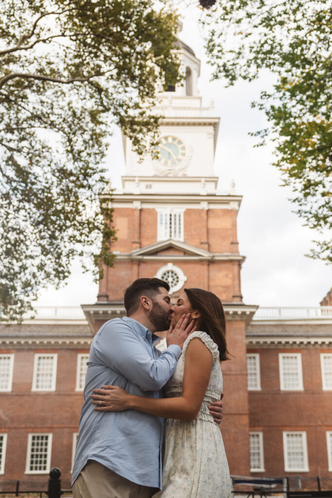 Couple shares a kiss in front of Independence Hall in Old City, Philadelphia, photographed by Philadelphia and New Jersey based travel wedding photographer, Madison Neumann Photography.