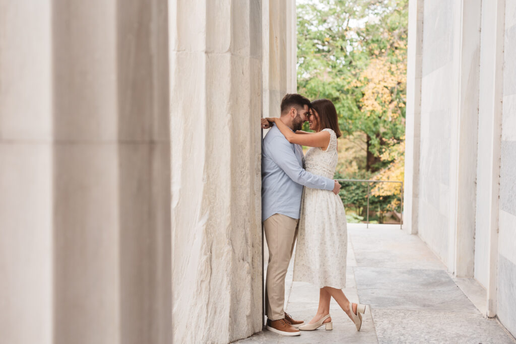 Couple embraces against pillar with their foreheads rested on one another, photographed by Philadelphia and New Jersey based travel wedding photographer, Madison Neumann Photography.