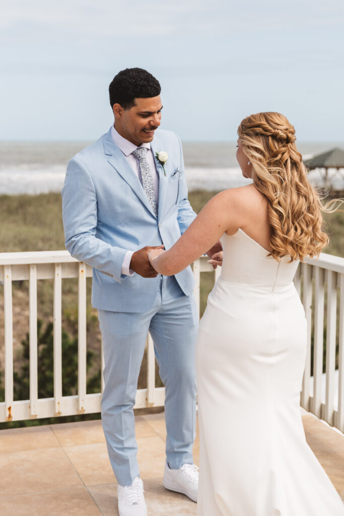 First look between bride and groom as the couple holds hands outside at the Outer Banks, photographed by New Jersey and Philadelphia based travel wedding photographer, Madison Neumann Photography.