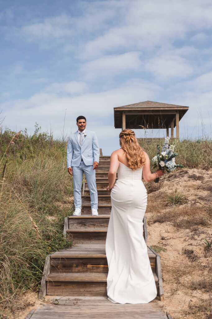 Bride walking up the steps that lead to the beaches of Outer Banks, NC, towards the groom, photographed by New Jersey and Philadelphia based travel wedding photographer, Madison Neumann Photography.