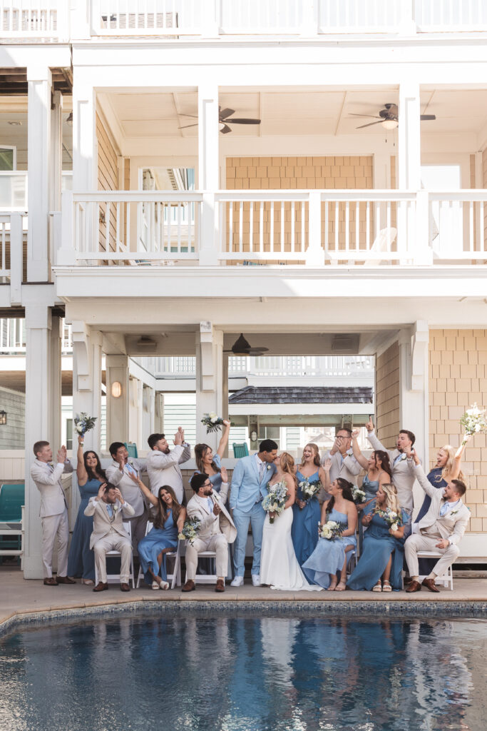 Bride and groom kiss with their bridal party celebrating their love in front of pool, photographed by New Jersey and Philadelphia based travel wedding photographer, Madison Neumann Photography.