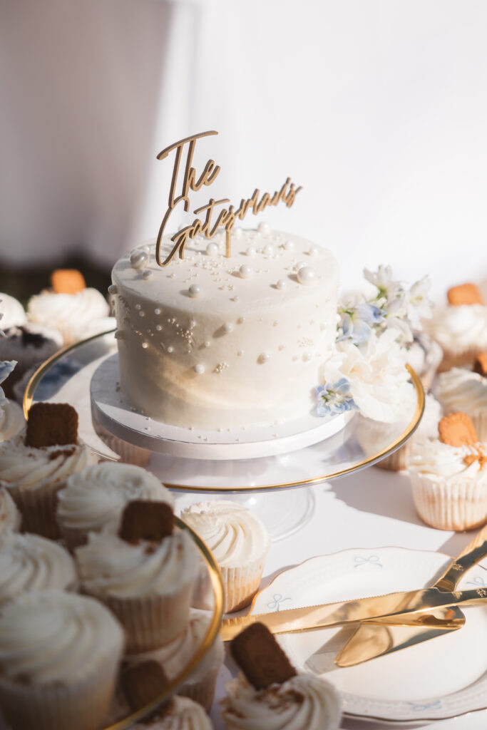Wedding cake with cupcakes surrounding it with gold silverware, photographed by New Jersey and Philadelphia based travel wedding photographer, Madison Neumann Photography.