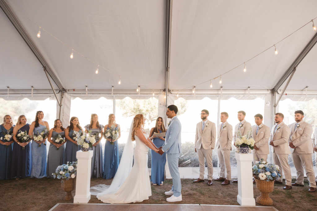 Bride and groom at the altar taken from the end of the aisle with most of the bridal party in the background, photographed by New Jersey and Philadelphia based travel wedding photographer, Madison Neumann Photography.