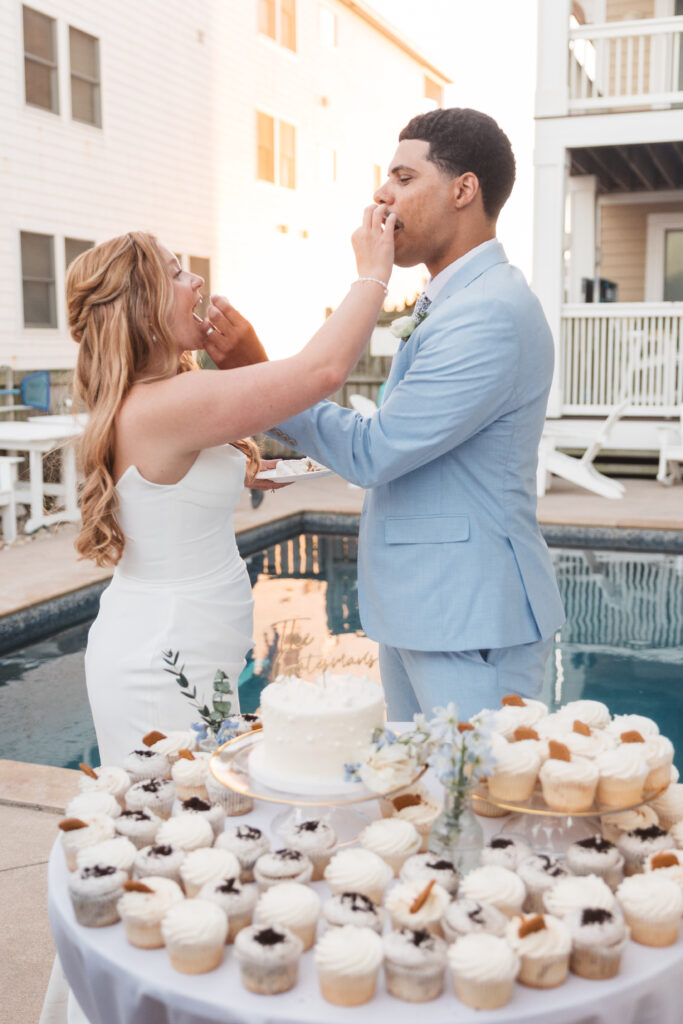 Bride and groom feed each other the first bites of cake in front of the pool, photographed by New Jersey and Philadelphia based travel wedding photographer, Madison Neumann Photography.