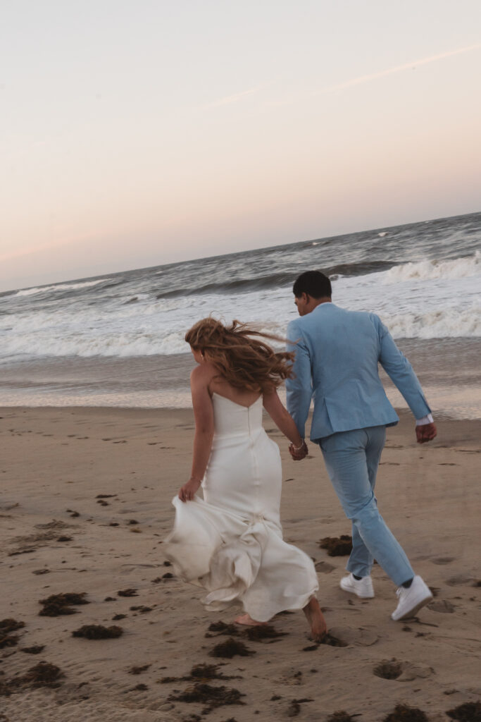 Bride and groom from behind on the beaches of Outer banks, NC during sunset with a slight romantic blur, photographed by New Jersey and Philadelphia based travel wedding photographer, Madison Neumann Photography.