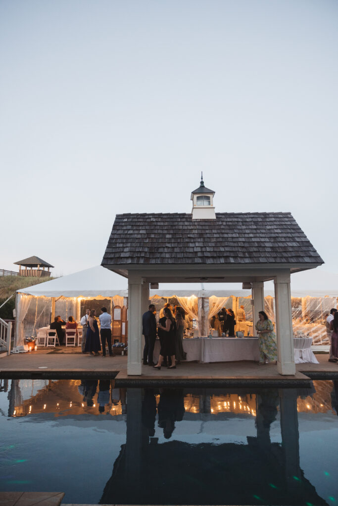 Shot of reception tent from across the pool in Outer Banks, NC, photographed by New Jersey and Philadelphia based travel wedding photographer, Madison Neumann Photography.