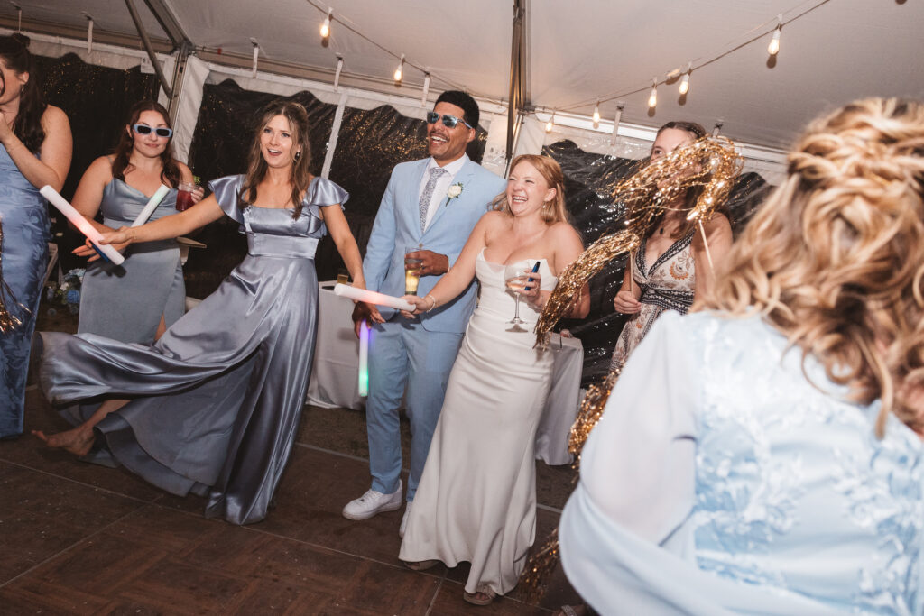 Bride and groom celebrate on the dance floor with their friends and family of their Outer Banks rental. Taken by travel, North Carolina wedding photographer Madison Neumann Photography.