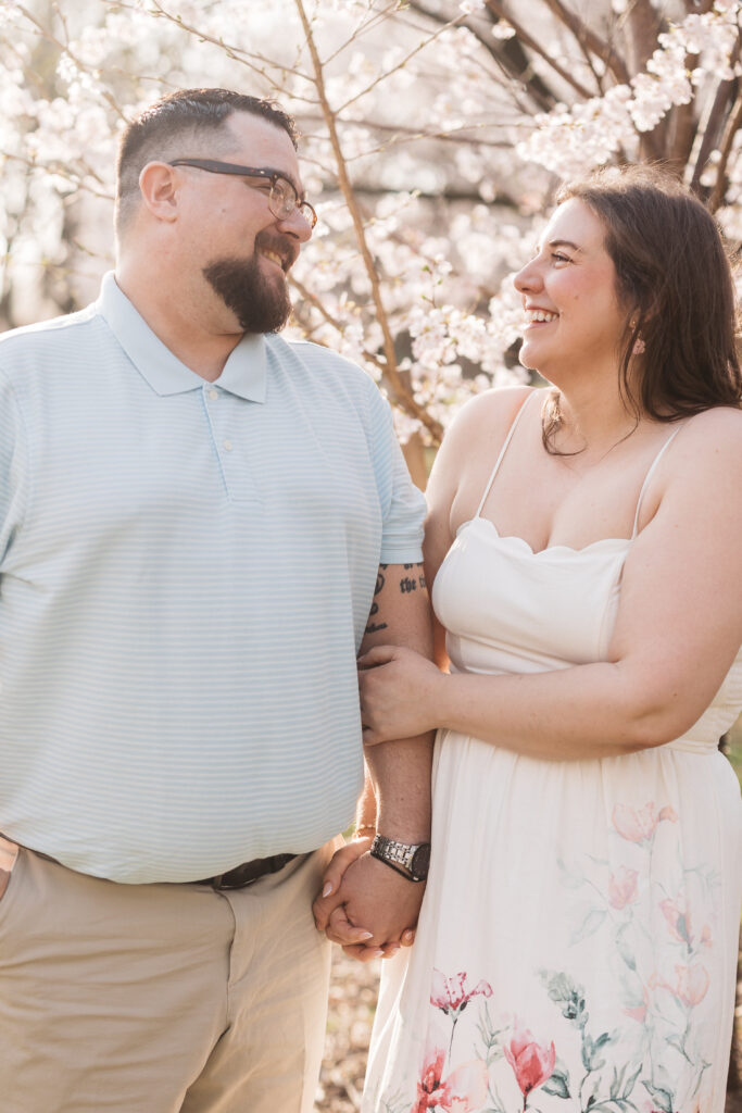 Loving looks being exchanged by the soon to be husband and wife surrounded by blossom trees in fairmont park, photographed by Philadelphia and New Jersey based travel wedding photographer, Madison Neumann Photography.