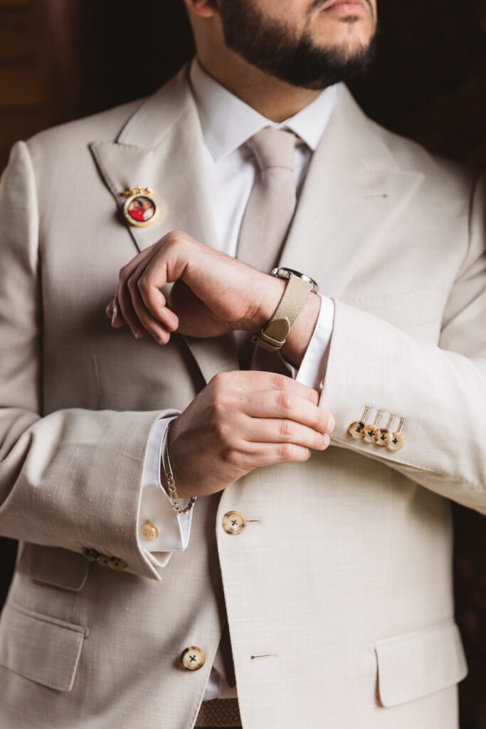 Zoomed in photo of the groom fixing his jacket, photographed by Philadelphia and New Jersey based travel wedding photographer, Madison Neumann Photography.