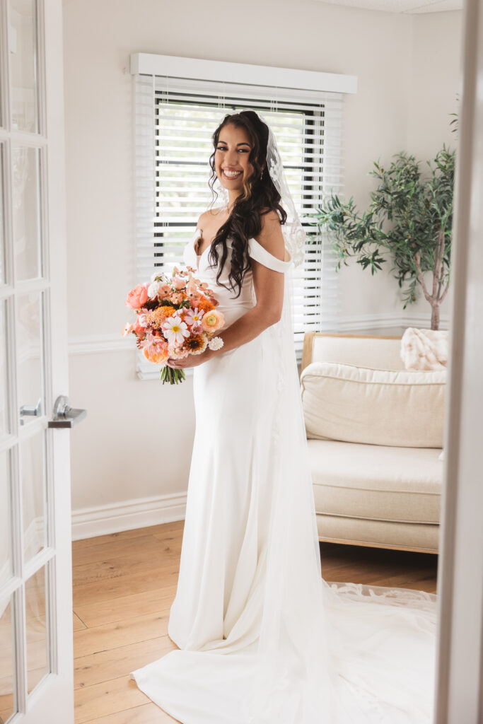 Portrait of the bride and her bouquet through French doors, photographed by Philadelphia and New Jersey based travel wedding photographer, Madison Neumann Photography.