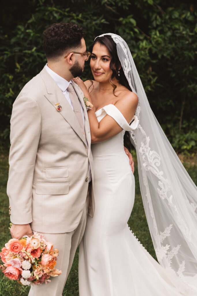 Bride looking into her grooms eyes and he hold her outside of Skyview Golf Course, photographed by Philadelphia and New Jersey based travel wedding photographer, Madison Neumann Photography.