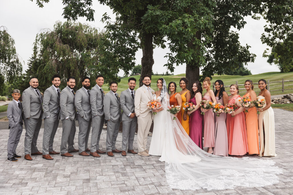 Bride and groom with their wedding party in front of the gold courses, photographed by Philadelphia and New Jersey based travel wedding photographer, Madison Neumann Photography.
