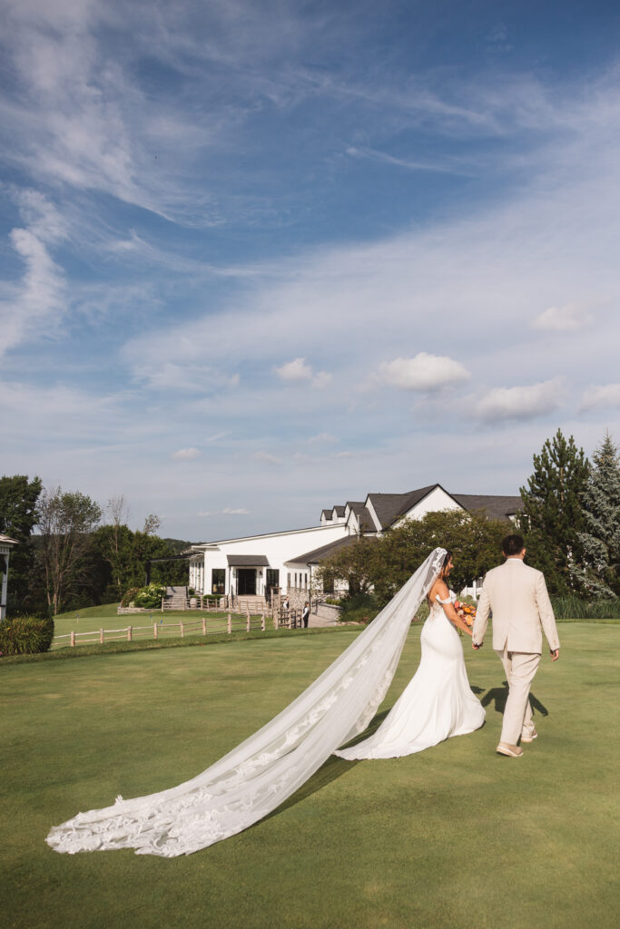 Newly-wed couple making their way inside from the Skyview Golf club, photographed by Philadelphia and New Jersey based travel wedding photographer, Madison Neumann Photography.