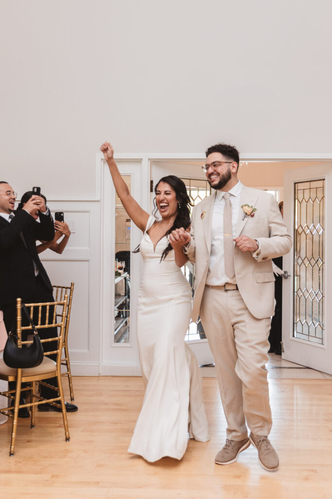 Mr. and Mrs. Make their entrance to their reception hand in hand, photographed by Philadelphia and New Jersey based travel wedding photographer, Madison Neumann Photography.