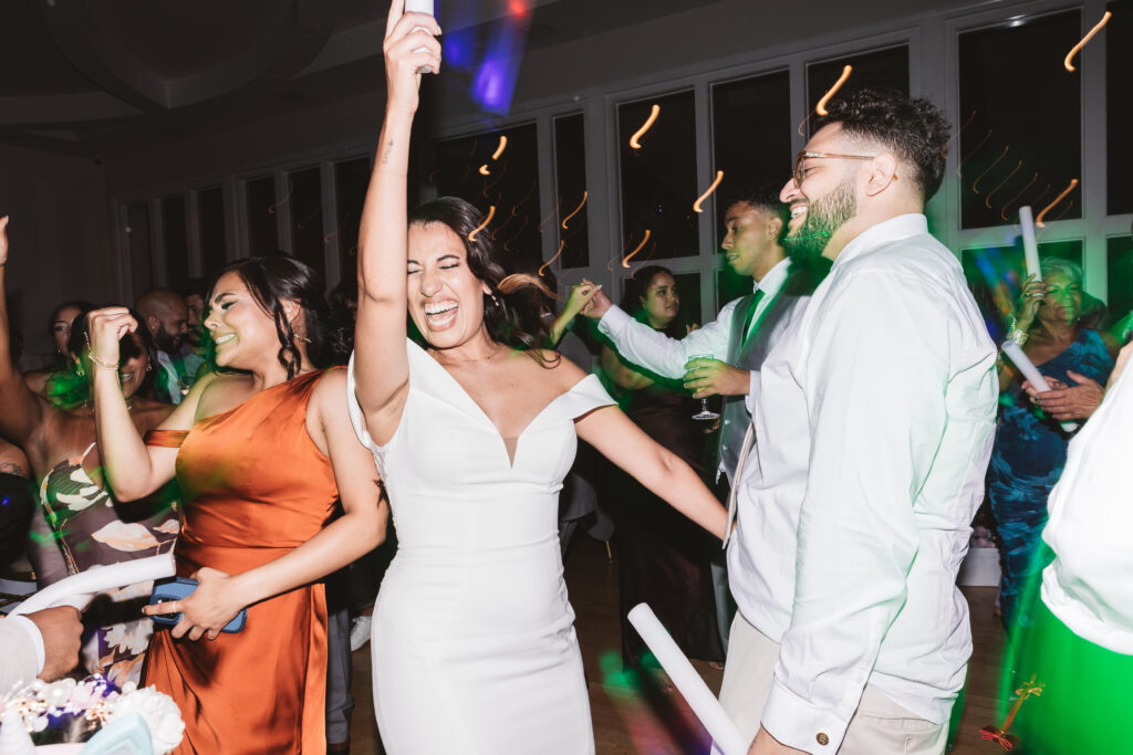 Additional photo of bride and groom partying and smiling with family as they dance, photographed by Philadelphia and New Jersey based travel wedding photographer, Madison Neumann Photography.