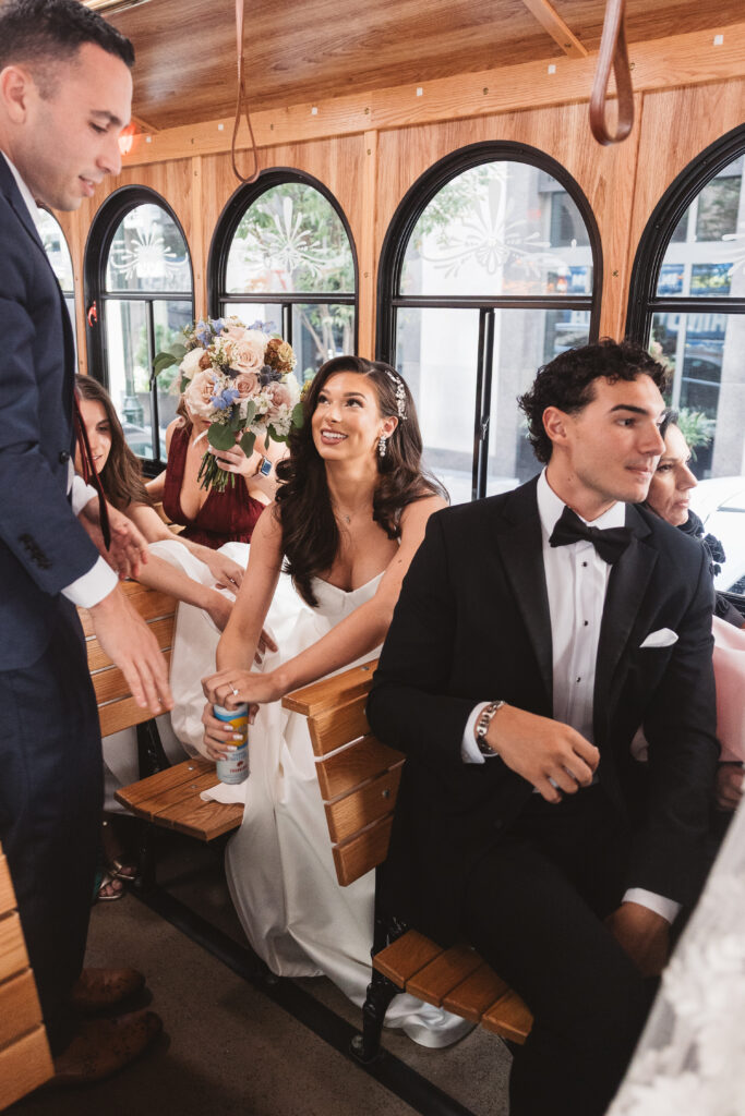 Bride and bridal party of the Cescephe trolley on the way to The Free Library for portraits with her soon to be husband, photographed by Philadelphia and New Jersey based travel wedding photographer, Madison Neumann Photography.