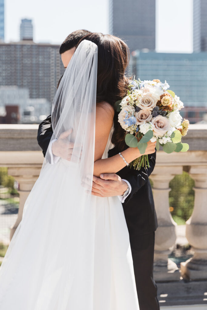 The couple shares an intimate hug after the first look on the rooftop of The Free Library in Philadelphia, photographed by Philadelphia and New Jersey based travel wedding photographer, Madison Neumann Photography.