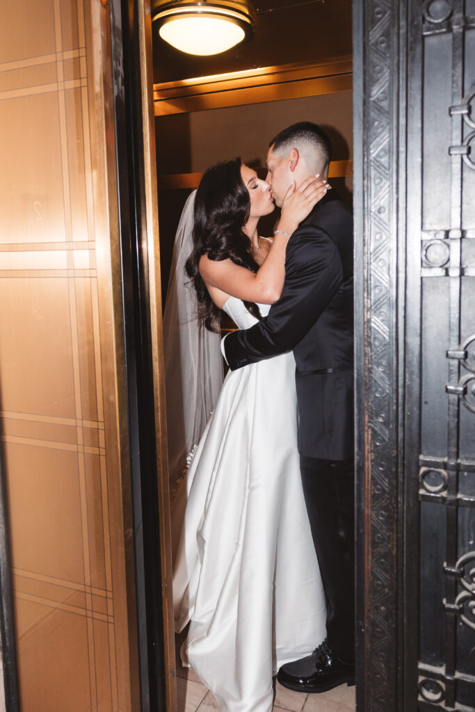 Bride and groom share a kiss in the elevator, photographed by Philadelphia and New Jersey based travel wedding photographer, Madison Neumann Photography.