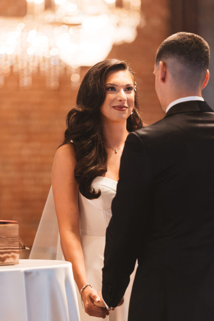Shot from behind the groom to see a beautiful blushing bride as they stand at the altar to become husband and wife, photographed by Philadelphia and New Jersey based travel wedding photographer, Madison Neumann Photography.