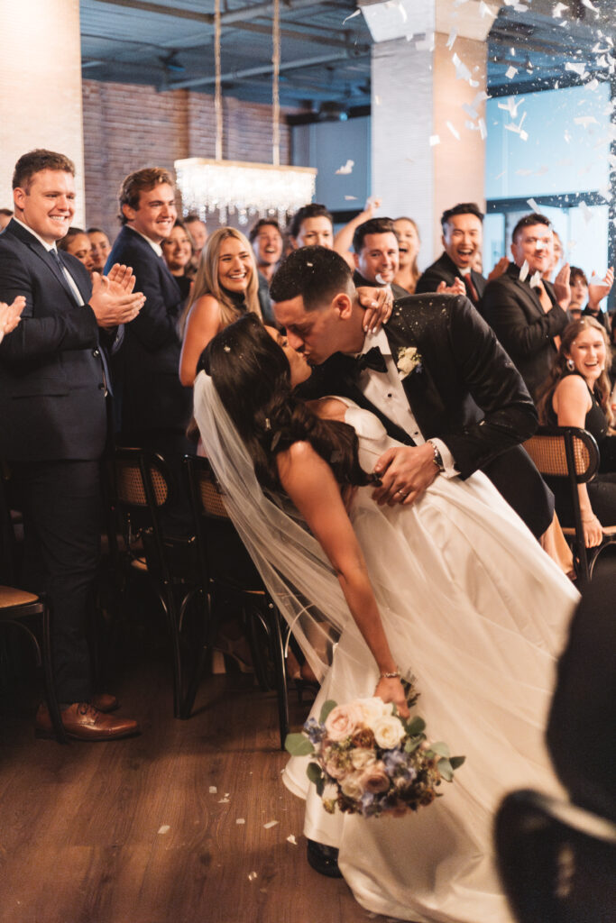 Dip kiss as the couple exits the ceremony, photographed by Philadelphia and New Jersey based travel wedding photographer, Madison Neumann Photography.