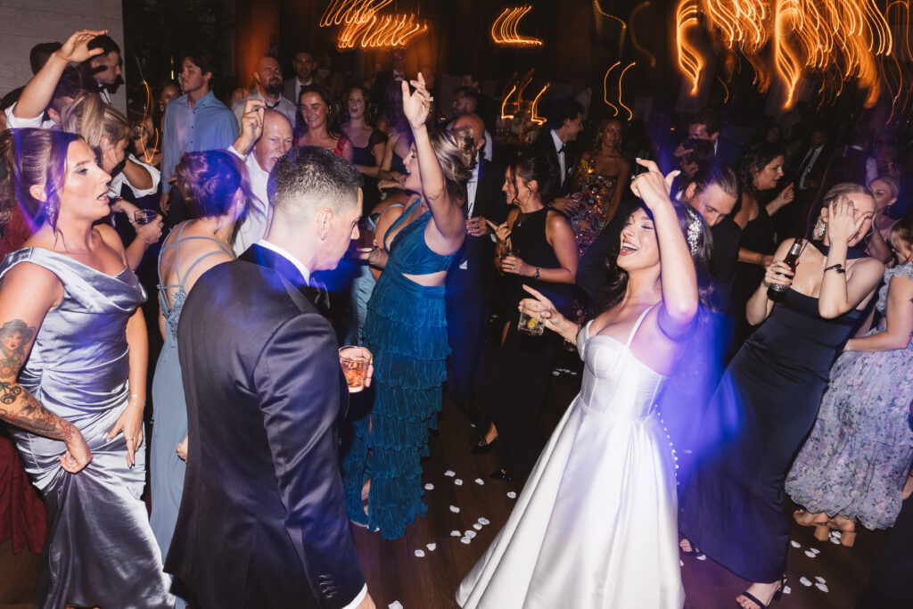 Fun and chaotic shot of bride and groom dancing with their guests, photographed by Philadelphia and New Jersey based travel wedding photographer, Madison Neumann Photography.