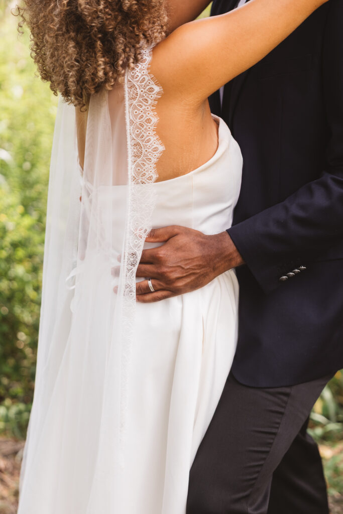 Detail shot of the grooms hands on his wife's waist with his wedding band shown, photographed by Philadelphia and New Jersey based travel wedding photographer, Madison Neumann Photography.