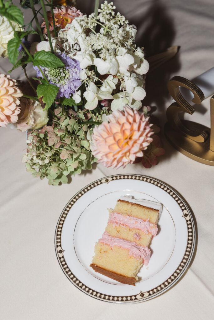 Closing shot of table decor, centerpiece, and a slice of wedding cake, photographed by Philadelphia and New Jersey based travel wedding photographer, Madison Neumann Photography.