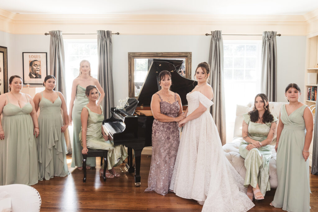 Portrait of bridal party ready for a day of celebrations in their getting ready suite in front of the grand piano, photographed by Philadelphia and New Jersey based travel wedding photographer, Madison Neumann Photography.