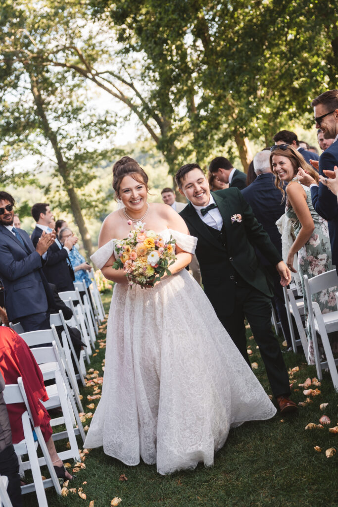 Bride and groom happy as can be while exiting their ceremony down the aisle, photographed by Philadelphia and New Jersey based travel wedding photographer, Madison Neumann Photography.