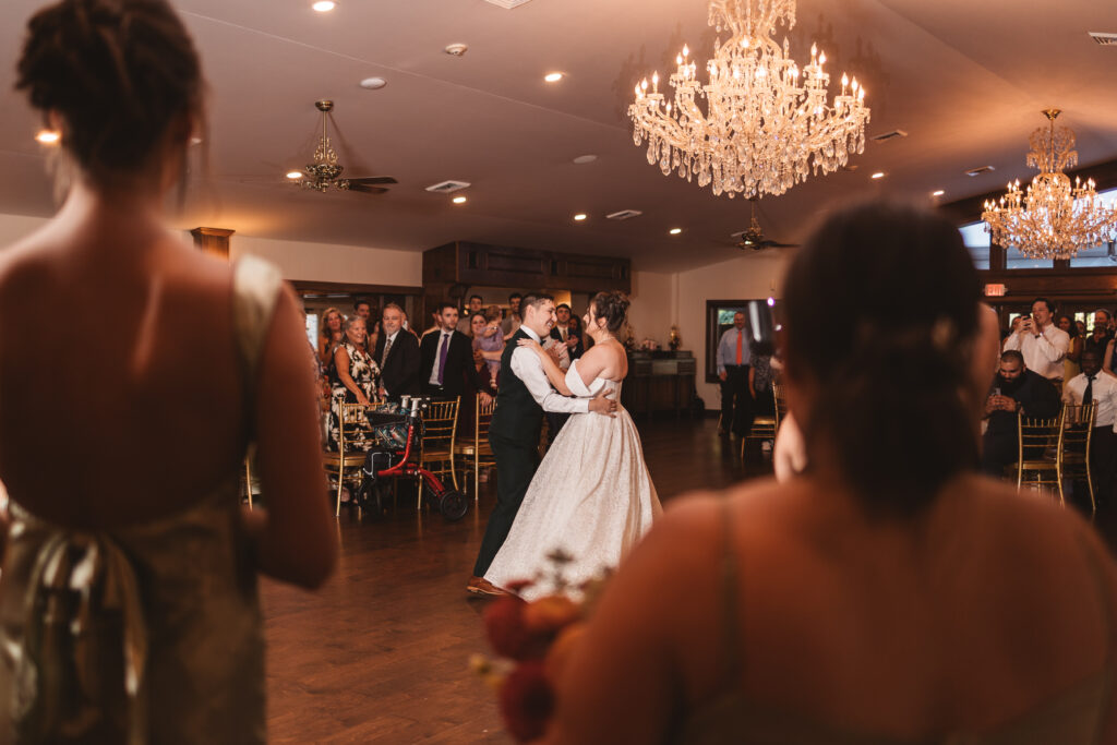 First dance and Mrs. and Mr. with beautiful chandeliers and onlooking loved ones, photographed by Philadelphia and New Jersey based travel wedding photographer, Madison Neumann Photography.