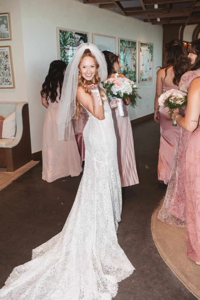 Bride blowing a kiss as she walks behind her bridal party, photographed by Philadelphia and New Jersey based travel wedding photographer, Madison Neumann Photography.
