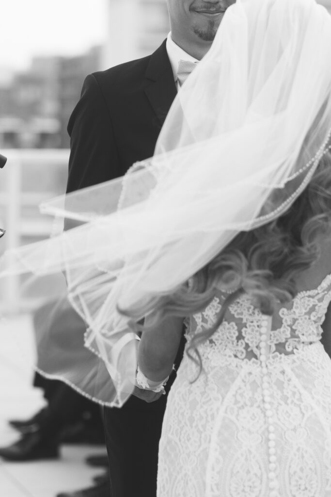 Black and white photos of the bride from behind with her veil flowing with the wind, photographed by Philadelphia and New Jersey based travel wedding photographer, Madison Neumann Photography.