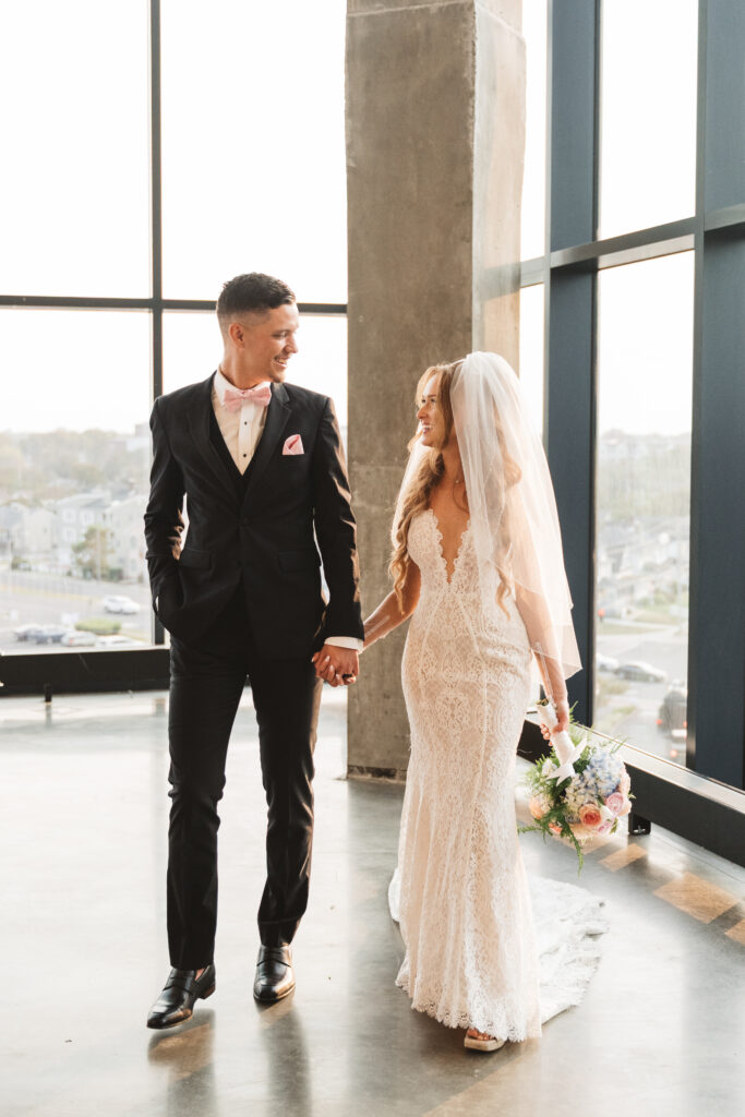 Bride and groom smile at each other while holding hands, photographed by Philadelphia and New Jersey based travel wedding photographer, Madison Neumann Photography.
