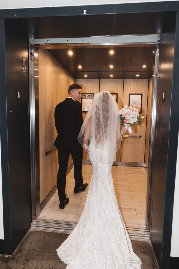 Portrait behind bride and groom as they enter the elevator at Wave Resort, photographed by Philadelphia and New Jersey based travel wedding photographer, Madison Neumann Photography.