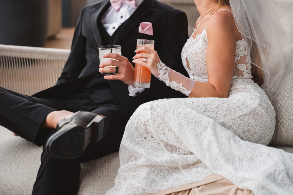 Detail shot of bride and groom lounging on a couch with their respective specialty cocktails, photographed by Philadelphia and New Jersey based travel wedding photographer, Madison Neumann Photography.